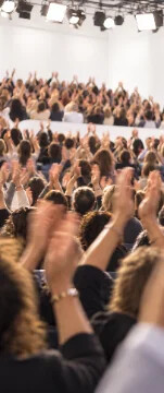 A studio audience clapping, hands raised mid-applause