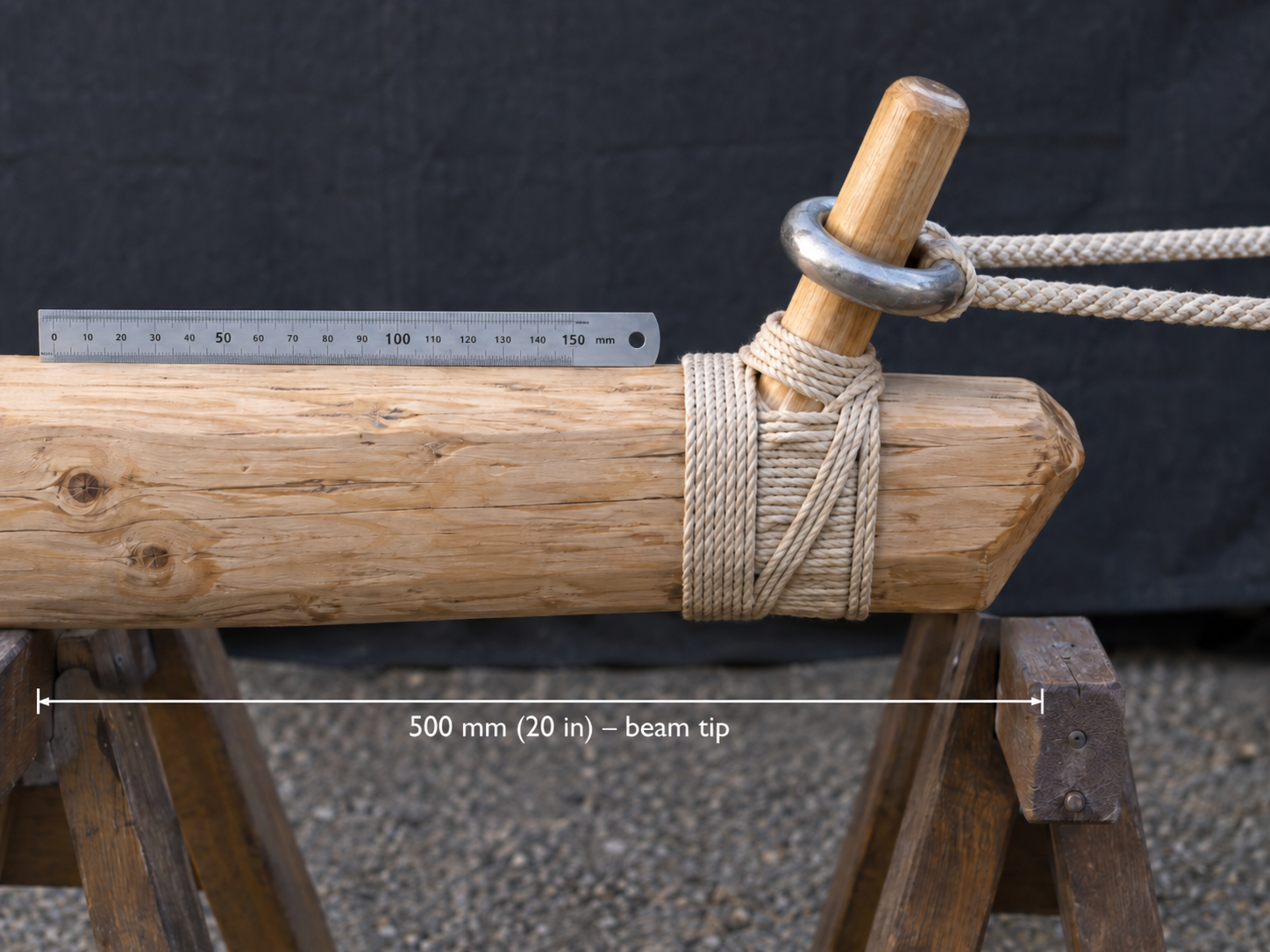 Close detail of the beam tip on trestles: hardwood release pin lashed into the beam with the sling ring seated over it and both lines running away taut